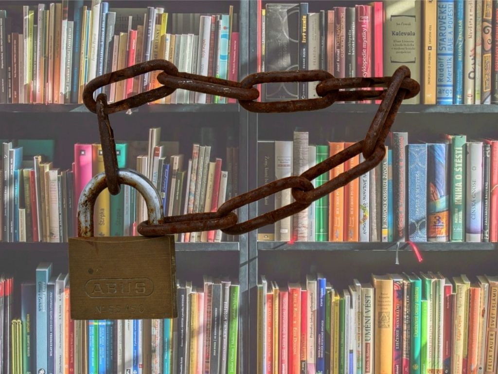 Regał z książkami owinięty starym łańcuchem z zamkniętą kłódką