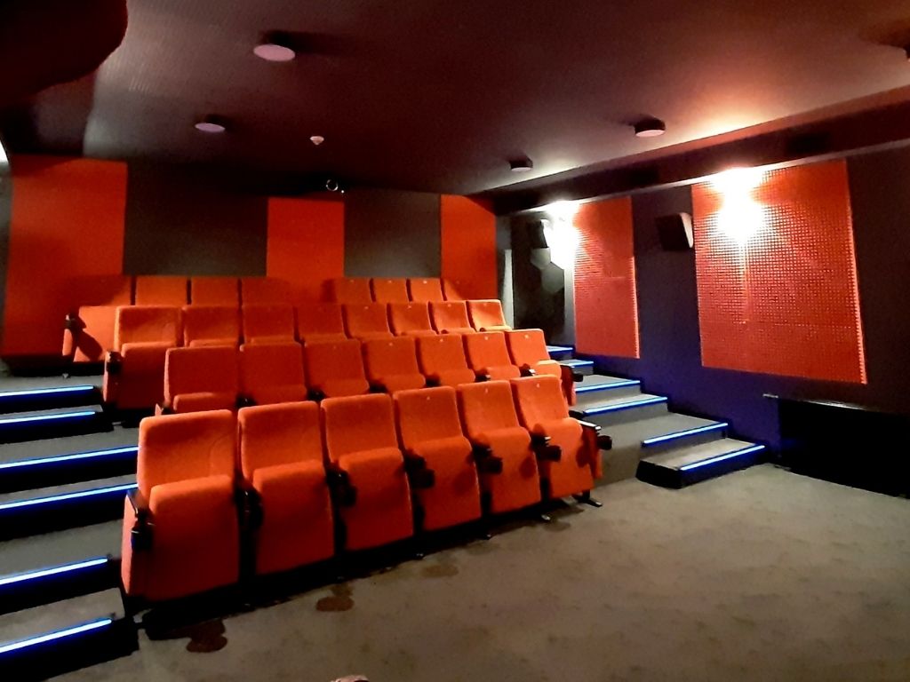 Sala kinowa: ściany w kolorze grafitowym, czerwone fotele